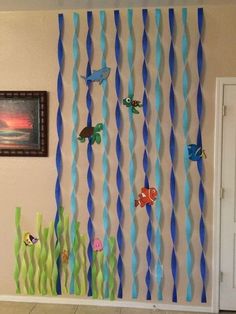 the wall is decorated with blue and green paper streamers, fish, and seaweed