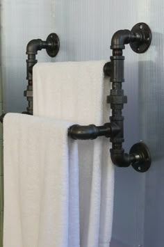 two black pipes are attached to the towel rack