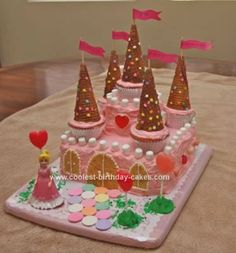 a pink castle cake with lots of decorations on it