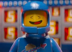 a lego man with a space suit and helmet in front of a slot machine that has the number five on it