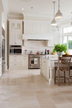 a large kitchen with white cabinets and an island