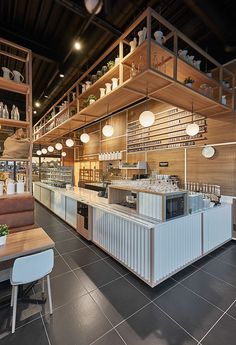 the interior of a restaurant with tables, chairs and shelves filled with dishes on top of them