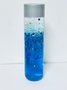 a water bottle filled with blue liquid on top of a white table