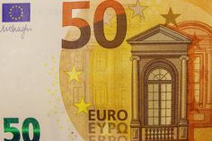 the 50 euros bill is shown in close up, with stars and buildings on it