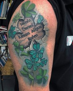 a man with a tattoo on his arm has clovers growing out of it