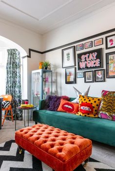 a living room filled with colorful furniture and pictures on the wall above it's headboard