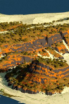 an aerial view of a mountain range with orange trees on the top and below it