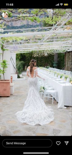 a woman in a wedding dress standing next to a table with white tables and chairs