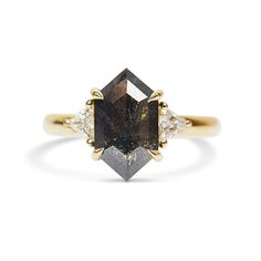 a yellow gold ring with a brown diamond and two white diamonds on the band, set in