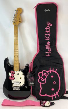 a hello kitty guitar case next to a black and pink guitar with hello kitty on it