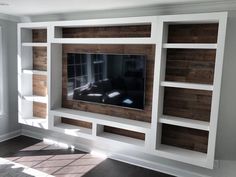 an entertainment center with built - in shelving and wood paneling on the wall