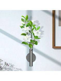 a metal vase with white flowers in it