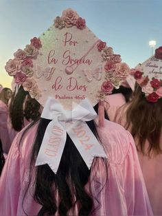 a group of women in pink gowns and hats with flowers on their heads are standing near each other