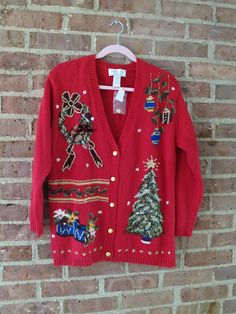 a red christmas sweater hanging on a brick wall