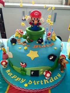 a blue birthday cake with mario on top