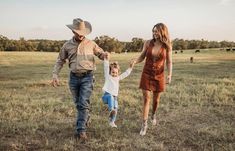 a man, woman and child walking in a field