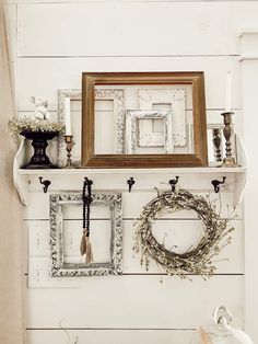 there is a mantle with pictures and wreaths on it, along with other items