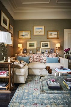 a living room filled with lots of furniture and pictures on the wall above it's coffee table