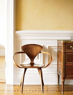 a chair sitting next to a dresser in a room