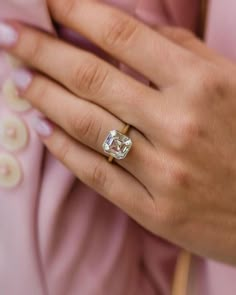 a close up of a person wearing a ring with a diamond on it's finger