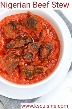 a white bowl filled with meatballs covered in sauce on top of a gray napkin