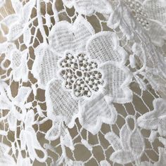 an image of white lace with flowers on the top and bottom part, close up