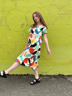 The Billie Dress is a prairie-style dress, featuring a flattering square neckline, short sleeves, loose fit, and the perfect length. Its airy fit mixed with the bold bright print makes it a comfortable everyday statement piece that can be dressed up or dressed down for any occasion. Hand sewn 100% Linen Cotton Printed with high-quality eco-friendly ink ***PLEASE READ BEFORE PURCHASE*** Please note that this garment is made to order, and production times can take up to two months. We recommend ch Casual Abstract Print Dress With Short Sleeves, Casual Short Sleeve Midi Dress With Vibrant Print, Casual Short Sleeve Multicolor Midi Dress, Casual Short Sleeve Dress With Retro Print, Casual Short Sleeve Retro Print Dress, Casual Multicolor Square Neck Midi Dress, Summer Dresses With Retro Print And Short Sleeves, Summer Dress With Retro Print And Short Sleeves, Childs Play