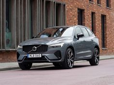 a grey volvo suv parked in front of a brick building