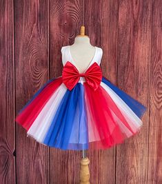 Your child can feel like a star! In her knee length red, white and blue tulle dress!  Bodice is made of white satin followed by a sowed in sash, followed by a deep V-Back with a hidden zipper. The big bow is detachable. The skirt consists of 3 multiple colored vertical tulle layers followed by two layers of soft white lining with crinoline to give it a fuller look. This specific dress is meant to be knee length, the size chart is located in the image section, it will be the last image and the measurements are in inches. Dress Is Pictured with a petticoat NOT INCLUDED https://www.etsy.com/listing/1316417982/white-knee-length-petticoat-wedding?click_key=41cb8b0ae4587efa582b0a433f3f5e0cde12aec0%3A1316417982&click_sum=af1df37b&ref=shop_home_active_1 Visit our store, more items to come!  https: Red Princess Dress For Summer Party, Red Tulle Dress For Summer, Red Tulle Summer Dress, White Fitted Tutu Dress For Christmas, White Fitted Christmas Tutu Dress, White Summer Dress For Celebrations, Summer Red Tutu Dress For Dress-up, Fitted Red Tutu Dress For Summer, Red Summer Tutu Dress Costume