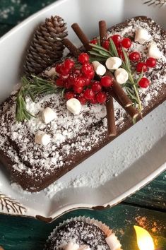 there is a piece of cake on the plate with berries and pine cones around it