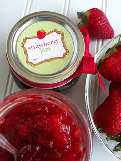 strawberries and jam are sitting on the table next to each other in glass bowls