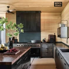 a kitchen with wooden walls and black cabinets