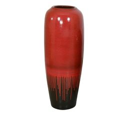 a red and black vase with dripping paint on the bottom is sitting in front of a white background