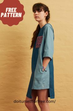 a woman standing in front of a wall wearing a blue dress with leopard print on it