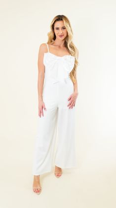 Adjustable spaghetti straps Zipper in back Some stretch Wide leg Metallic bow on chest Lined/non-sheer 95% Polyester; 5% Spandex SIZES: SMALL MEDIUM LARGE Introducing our Spaghetti Strap Big Bow Jumpsuit in a stunning off white color! Perfect for brides-to-be or anyone looking for a chic and unique outfit. Stand out with the playful and stylish big bow detail. Makes a statement without trying too hard! SIZE XS S M L XL 2XL 3XL FITS A SIZE 00-0 2-4 6-8 10-12 14-16 18-20 22-24 White Sleeveless Jumpsuit With Ruffles, White Sleeveless Ruffled Jumpsuit, Chic White Tie-back Jumpsuit, White V-neck Jumpsuit With Tie Waist, White Stretch Wide-leg Jumpsuit, Platform Heels Boots, Unique Outfit, Sandal Platform, Blue And White Dress