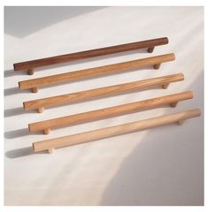 four wooden dowels are lined up on a white surface