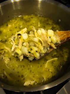 a wooden spoon is being used to stir some food in a pot on the stove