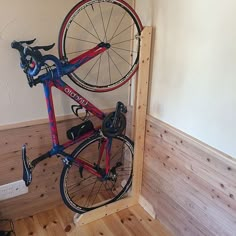 a bicycle is mounted to the side of a wooden wall in a room with wood flooring