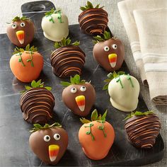 chocolate covered strawberries are arranged in the shape of birds and carrots with faces on them