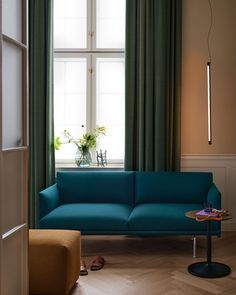 a blue couch sitting in front of a window