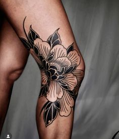 a woman's leg with black and white flowers on it