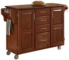 a kitchen island cart with drawers on wheels and a bowl of food on top of it