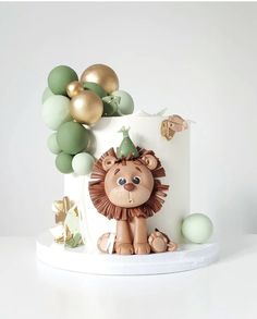 a birthday cake decorated with balloons and a lion figurine