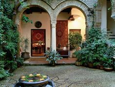 an outdoor courtyard with potted plants on the ground