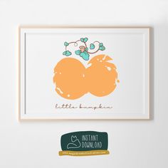 two oranges are hanging on the wall next to a sign that says little pumpkin