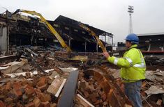 a man standing in front of a pile of rubble