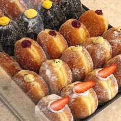 a tray filled with pastries covered in icing and strawberries on top of each other