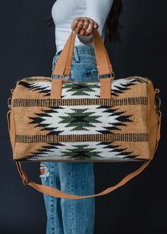 Stay organized and fashionable with our new Aztec inspired duffel. This brown, black, green and cream Aztec inspired duffel is a must have for the fall season ahead. Brown, black, green and cream Aztec inspired duffel Zipper closure with interior zipper and 2 small open pockets Removable strap Measures 20" x 8" x 11" Designed in the U.S.A. Produced in India. 100% Cotton Lining: 100% Polyester Puzzle Jewelry, Sac Week End, Graphic Tee Dress, Aztec Designs, Duffel Bags, Color Inspo, Pretty Patterns, Green Cream, Aztec Print