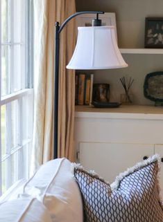 a living room with a lamp and some pillows