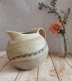 two vases sitting next to each other on a wooden table